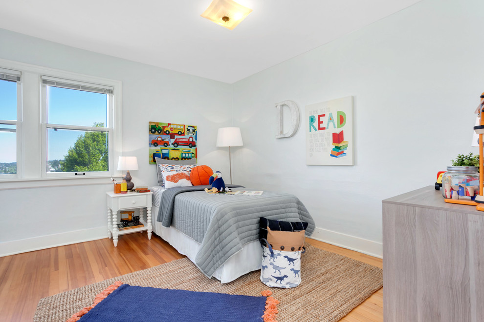 Mid-sized transitional kids' bedroom in Seattle with green walls and light hardwood floors for kids 4-10 years old and boys.