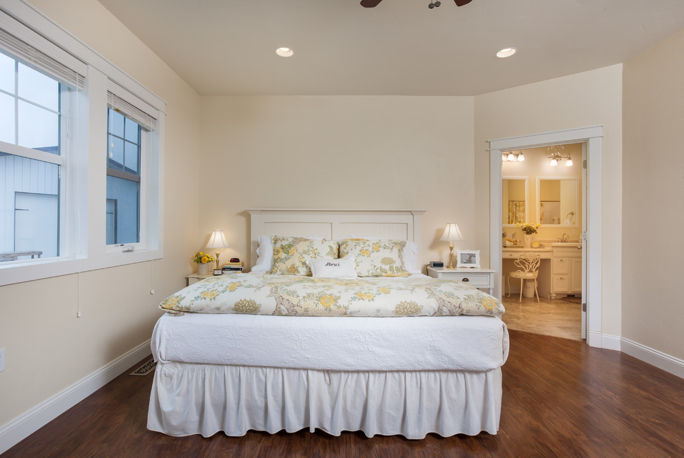 他の地域にある中くらいなトランジショナルスタイルのおしゃれな主寝室 (黄色い壁、無垢フローリング、茶色い床) のインテリア