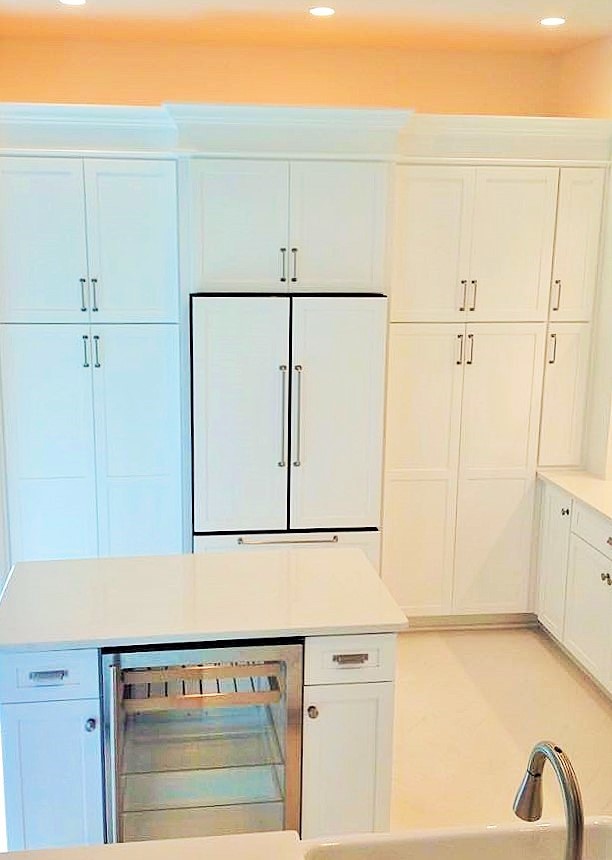 This is an example of a mid-sized contemporary u-shaped kitchen pantry in Miami with a farmhouse sink, shaker cabinets, white cabinets, quartz benchtops, stainless steel appliances, with island, white splashback and ceramic floors.