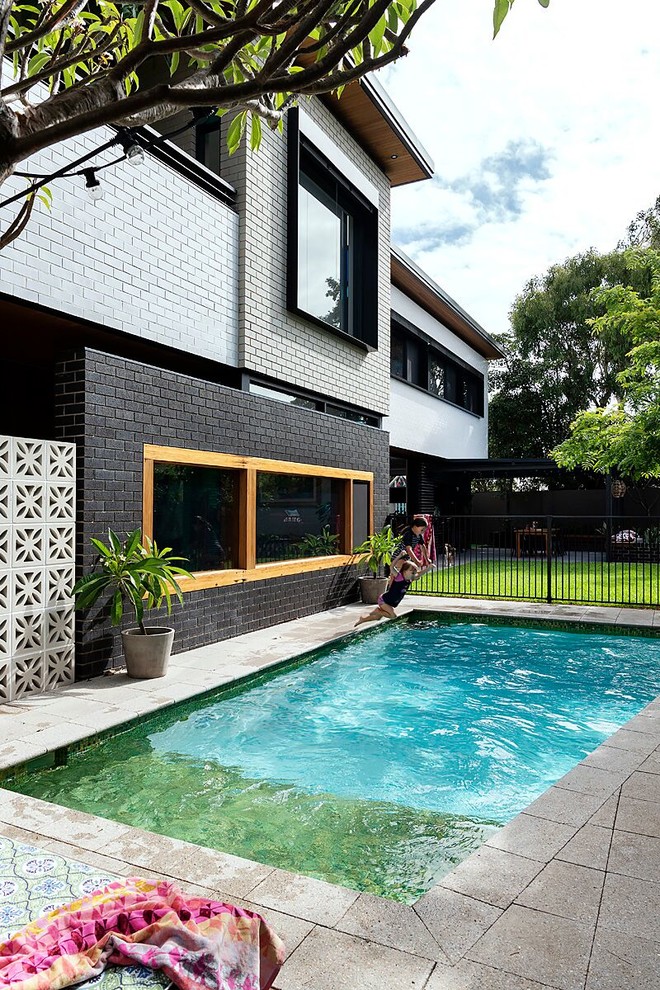 This is an example of a mid-sized midcentury backyard rectangular lap pool in Perth.