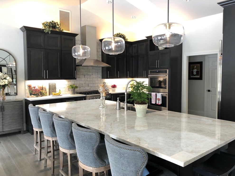 Example of a mid-sized transitional kitchen design with quartzite countertops and an island