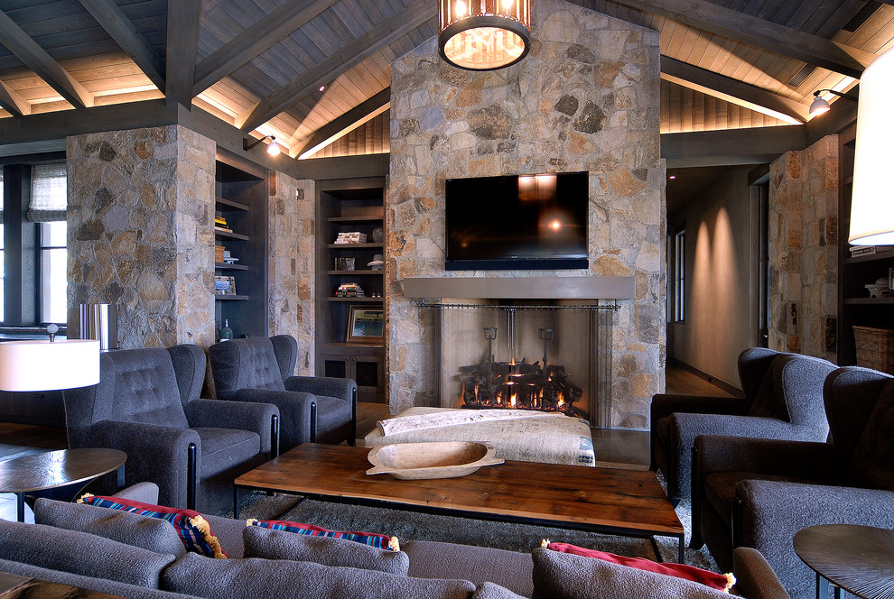 Design ideas for a large country formal open concept living room in Denver with multi-coloured walls, dark hardwood floors, a standard fireplace, a stone fireplace surround, a wall-mounted tv and brown floor.