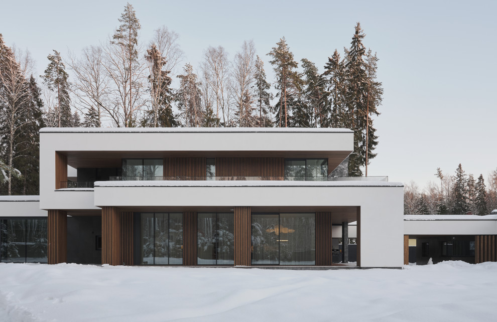 Идея дизайна: большой, двухэтажный, белый дом в современном стиле с комбинированной облицовкой, плоской крышей, крышей из смешанных материалов, черной крышей и отделкой планкеном