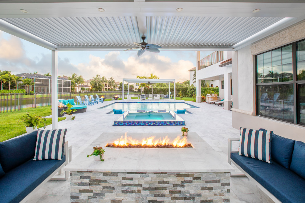 Large transitional backyard rectangular pool in Miami with a hot tub and tile.