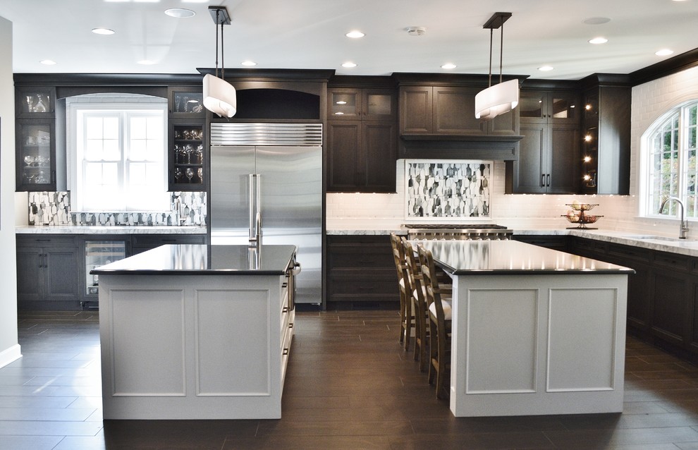 Inspiration for a large transitional l-shaped dark wood floor enclosed kitchen remodel in DC Metro with an undermount sink, dark wood cabinets, white backsplash, subway tile backsplash, stainless steel appliances, two islands and shaker cabinets