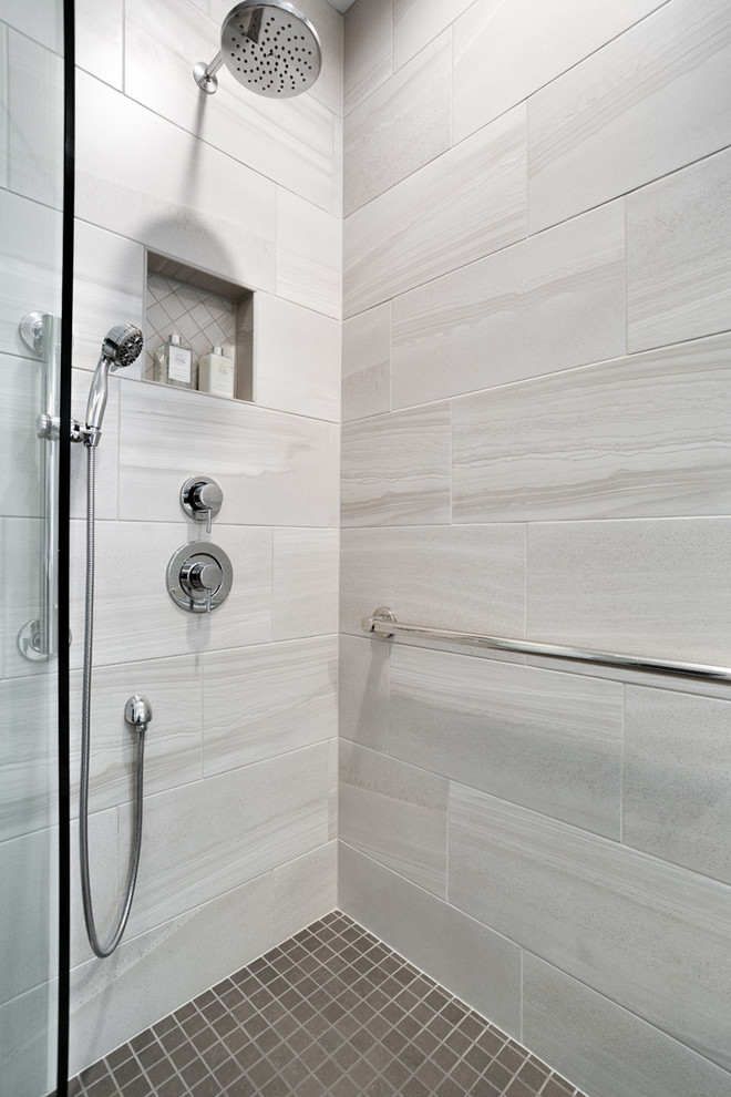 Photo of a mid-sized transitional master bathroom in DC Metro with recessed-panel cabinets, grey cabinets, an undermount tub, an alcove shower, gray tile, ceramic tile, grey walls, ceramic floors, an undermount sink, engineered quartz benchtops, grey floor, a hinged shower door and white benchtops.