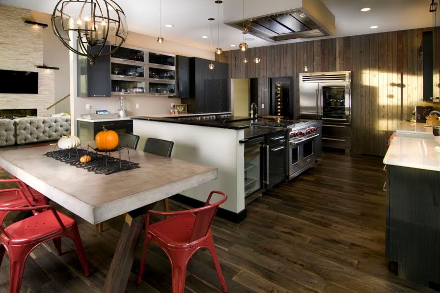 Inspiration for a huge rustic u-shaped dark wood floor and brown floor open concept kitchen remodel in Cedar Rapids with a farmhouse sink, flat-panel cabinets, black cabinets, stainless steel appliances and an island