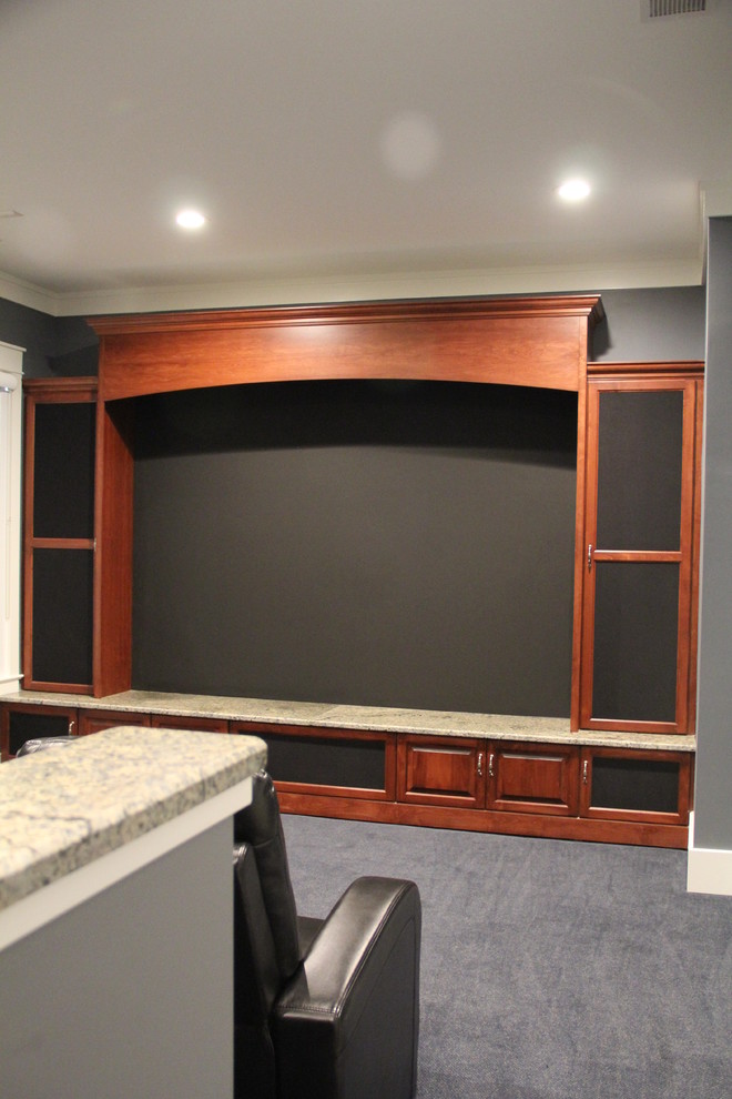 Large arts and crafts enclosed carpeted home theater photo in Charlotte with a media wall