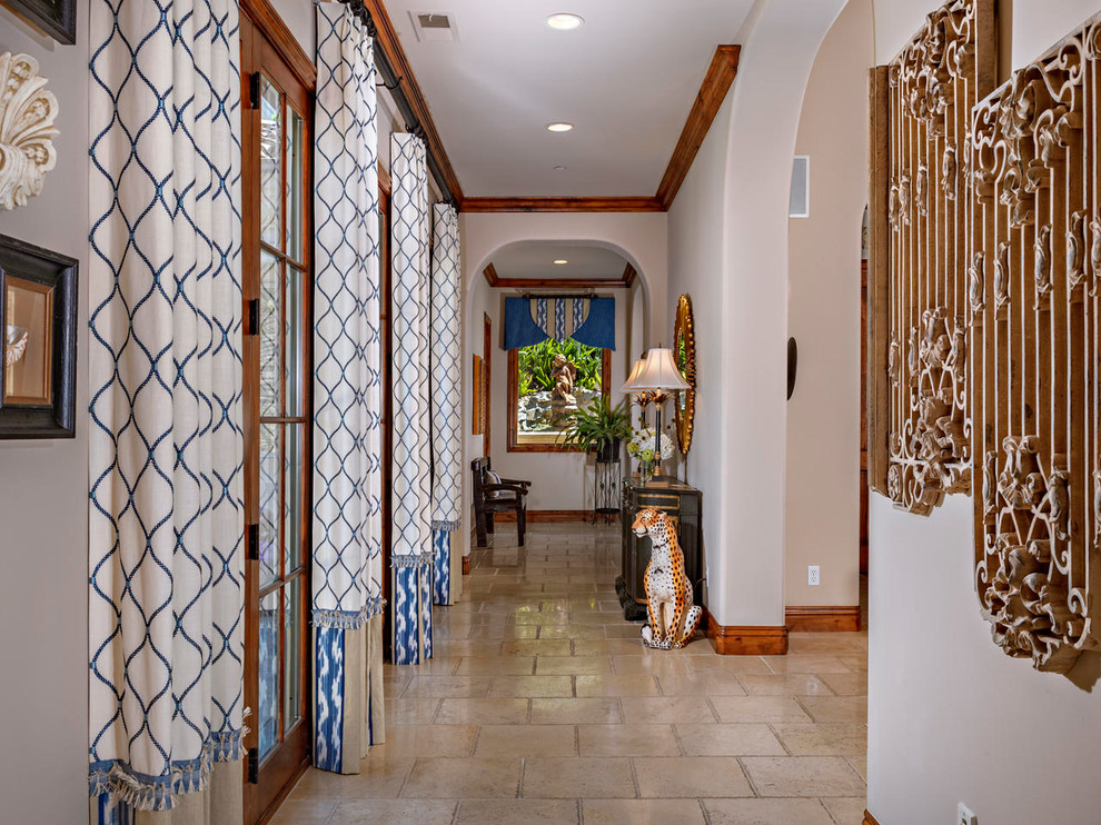 Inspiration for a large beach style hallway in San Diego with beige walls, travertine floors and beige floor.