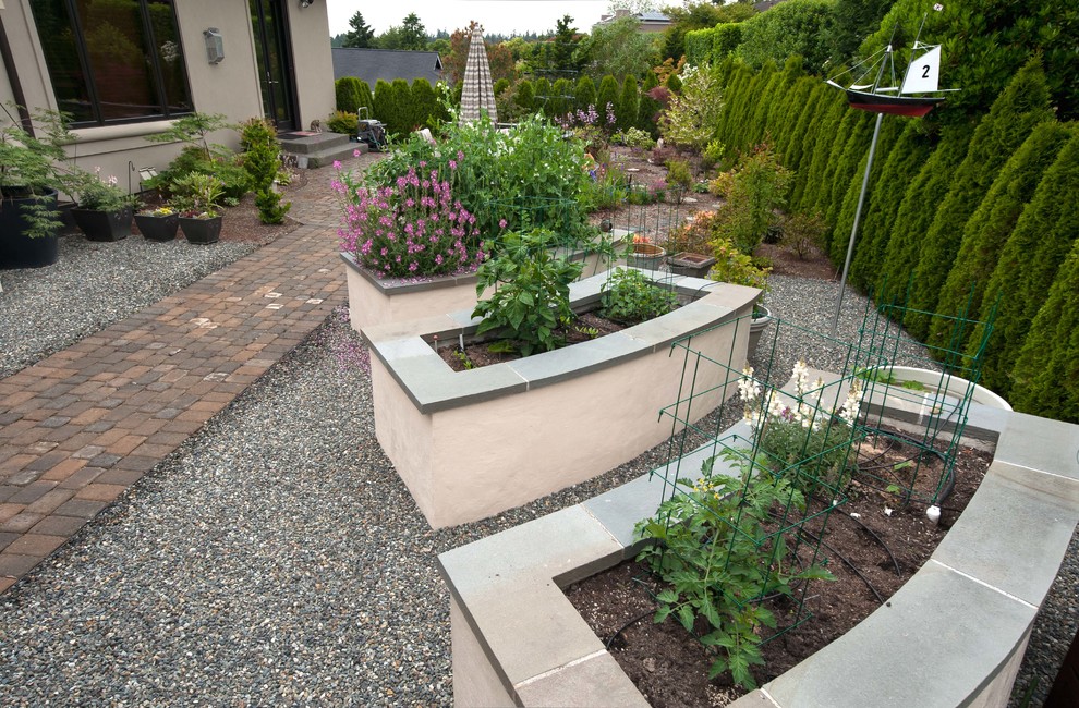 Large traditional backyard formal garden in Seattle with a vegetable garden and natural stone pavers.
