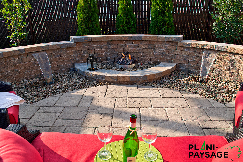 This is an example of a small contemporary backyard patio in Montreal with a fire feature and concrete pavers.
