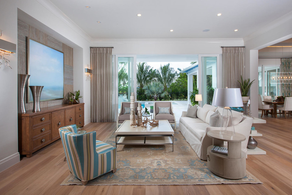 Tropical formal open concept living room in Miami with light hardwood floors and no fireplace.