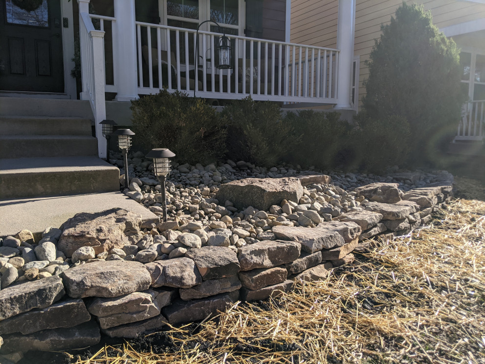 This is an example of a mid-sized rock front yard river rock landscaping in Other.