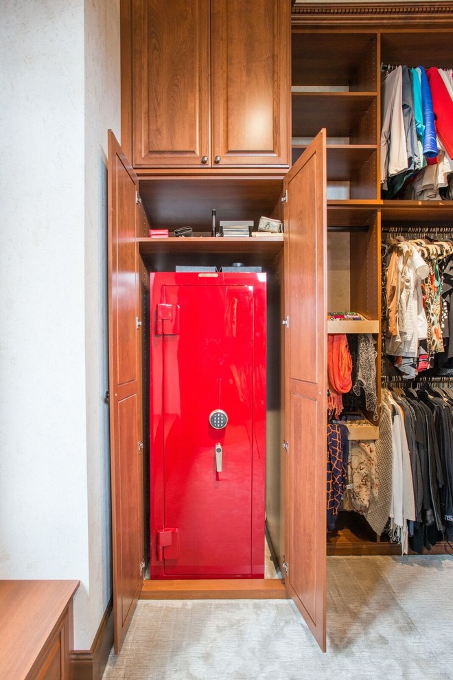 Inspiration for a mid-sized traditional gender-neutral walk-in wardrobe in Denver with raised-panel cabinets, medium wood cabinets, carpet and beige floor.