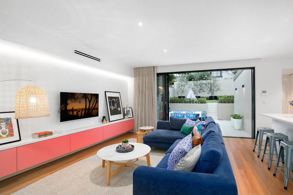 Inspiration for a contemporary open concept living room in Sydney with white walls, medium hardwood floors, no fireplace, a wall-mounted tv and brown floor.
