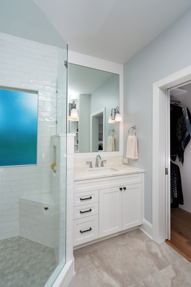 Свежая идея для дизайна: главная ванная комната среднего размера в стиле неоклассика (современная классика) с фасадами в стиле шейкер, белыми фасадами, угловым душем, раздельным унитазом, белой плиткой, керамической плиткой, синими стенами, полом из керамогранита, врезной раковиной, мраморной столешницей, бежевым полом, душем с распашными дверями, белой столешницей, нишей, тумбой под две раковины и встроенной тумбой - отличное фото интерьера
