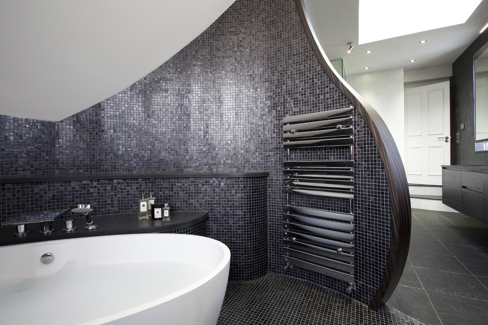 This is an example of a contemporary bathroom in London with a freestanding tub and mosaic tile.
