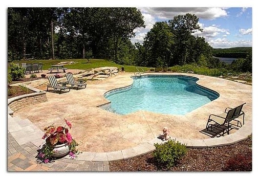 Backyard stone and custom-shaped pool photo