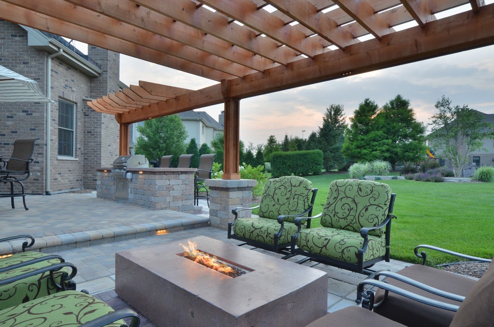 Inspiration for a mid-sized traditional backyard patio in Chicago with an outdoor kitchen, concrete pavers and a pergola.