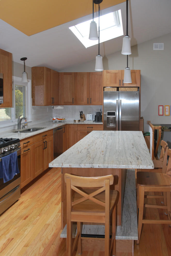 Inspiration for a large transitional l-shaped medium tone wood floor enclosed kitchen remodel in Boston with an undermount sink, recessed-panel cabinets, medium tone wood cabinets, granite countertops, beige backsplash, ceramic backsplash, stainless steel appliances and an island