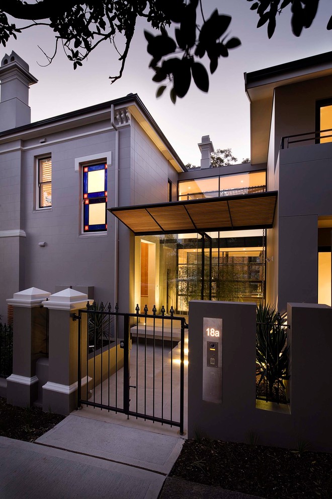 Contemporary front door in Sydney with grey walls, concrete floors and a glass front door.