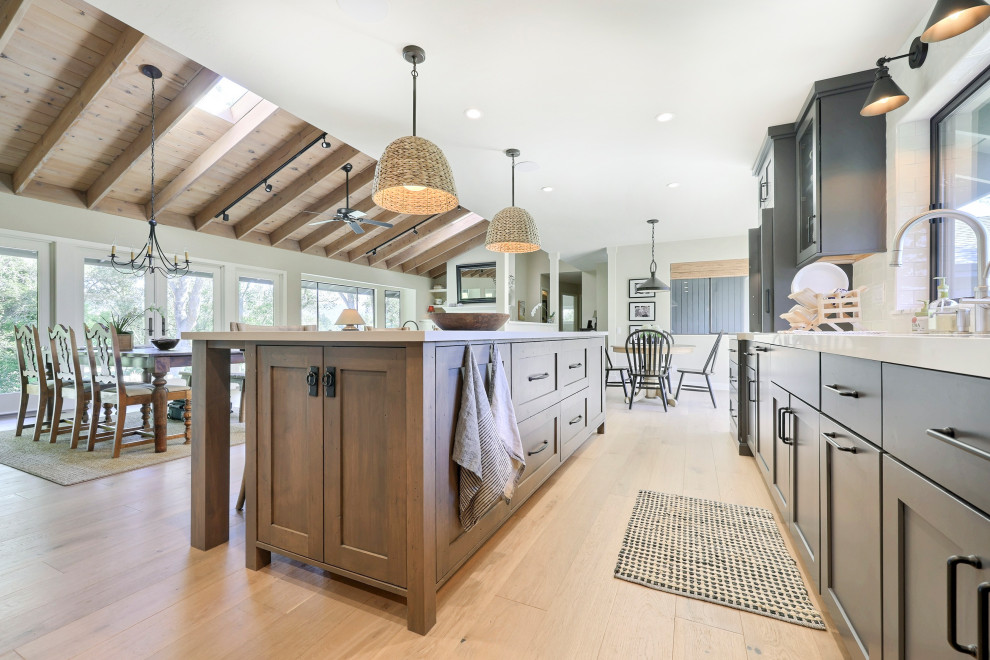 Open concept kitchen - mid-sized transitional l-shaped laminate floor open concept kitchen idea with a double-bowl sink, flat-panel cabinets, gray cabinets, quartz countertops, white backsplash, ceramic backsplash, stainless steel appliances, an island and white countertops