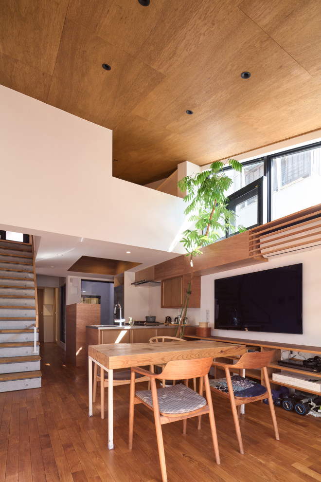 This is an example of a mid-sized modern open plan dining in Tokyo with white walls, medium hardwood floors, no fireplace, brown floor, wood and planked wall panelling.