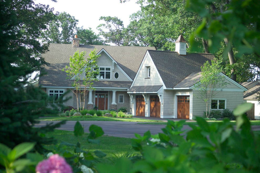 This is an example of a large transitional three-storey beige exterior in Grand Rapids with concrete fiberboard siding and a gable roof.