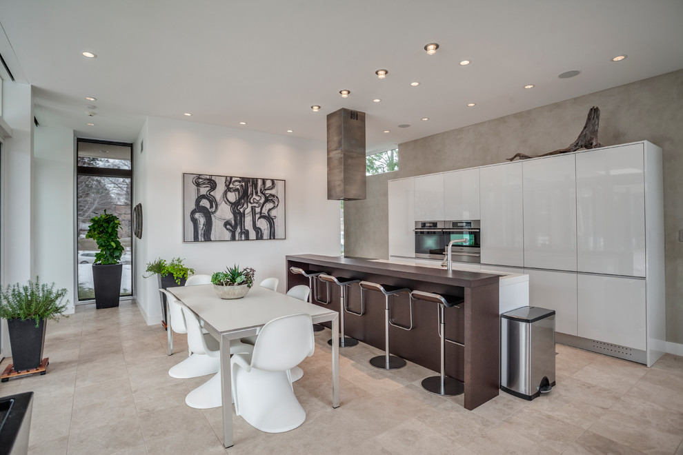 Contemporary eat-in kitchen in Minneapolis with flat-panel cabinets, white cabinets, stainless steel appliances, with island, beige floor and ceramic floors.