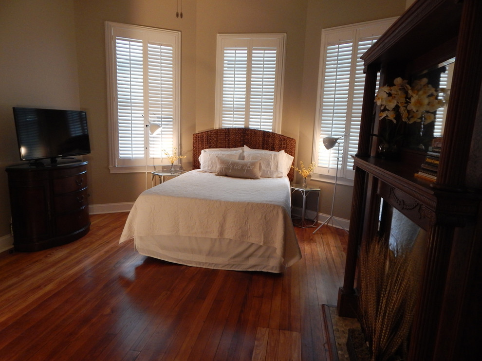 Large transitional guest bedroom in Other with grey walls, medium hardwood floors and a standard fireplace.