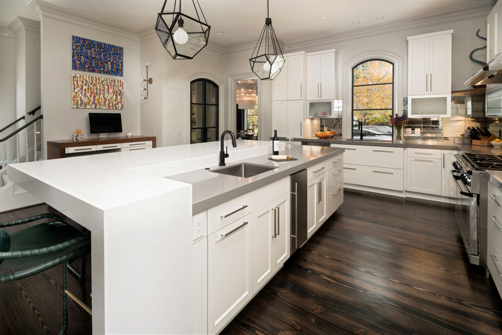 Inspiration for a large transitional l-shaped open plan kitchen in Charlotte with an undermount sink, shaker cabinets, white cabinets, quartz benchtops, metallic splashback, mirror splashback, panelled appliances, dark hardwood floors, with island, brown floor and grey benchtop.