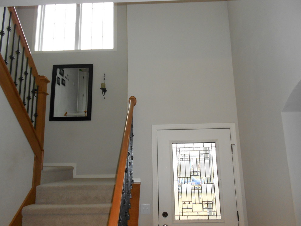 Front door - small transitional ceramic tile front door idea in Milwaukee with beige walls and a white front door