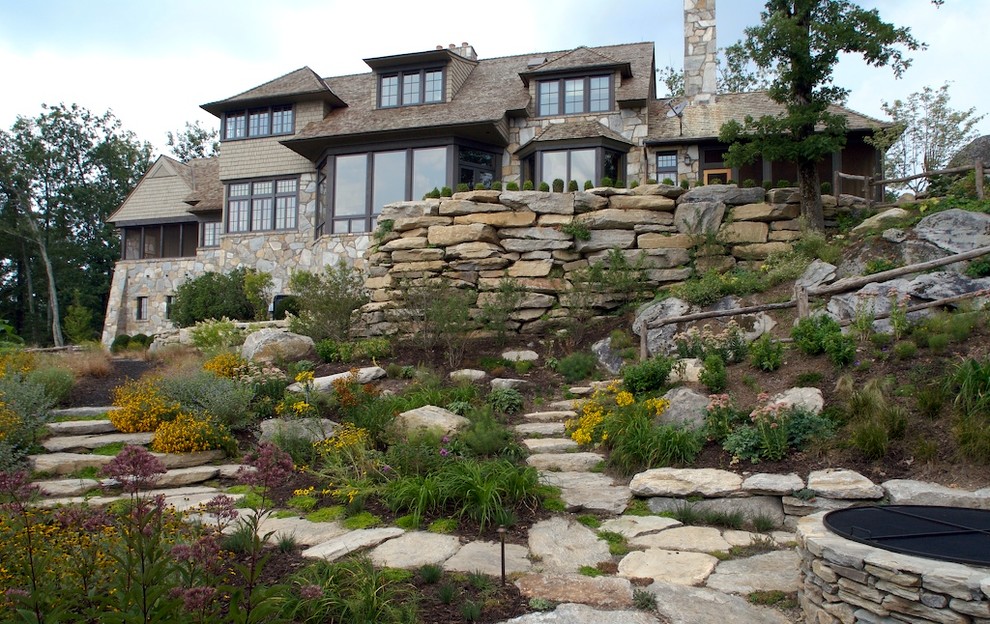 Photo of a traditional sloped garden in Other with natural stone pavers.