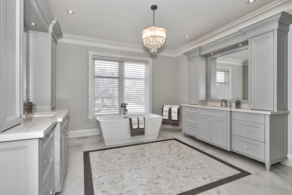 Inspiration for a large contemporary master bathroom in Toronto with shaker cabinets, grey cabinets, a freestanding tub, a curbless shower, white tile, grey walls, marble floors, an undermount sink and engineered quartz benchtops.