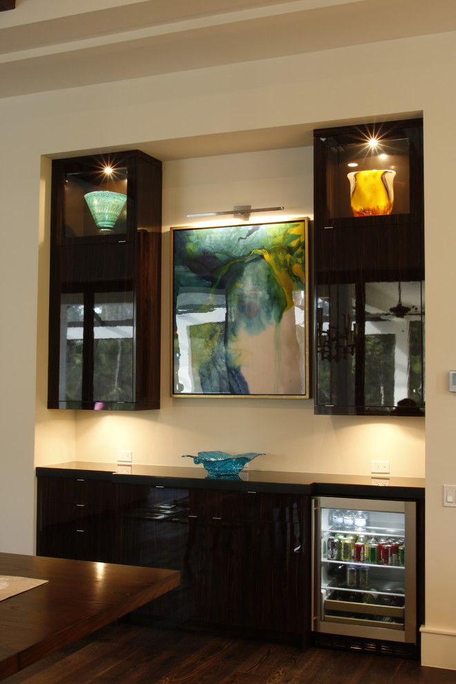 Design ideas for a mid-sized eclectic wet bar in Tampa with flat-panel cabinets, dark wood cabinets and granite benchtops.