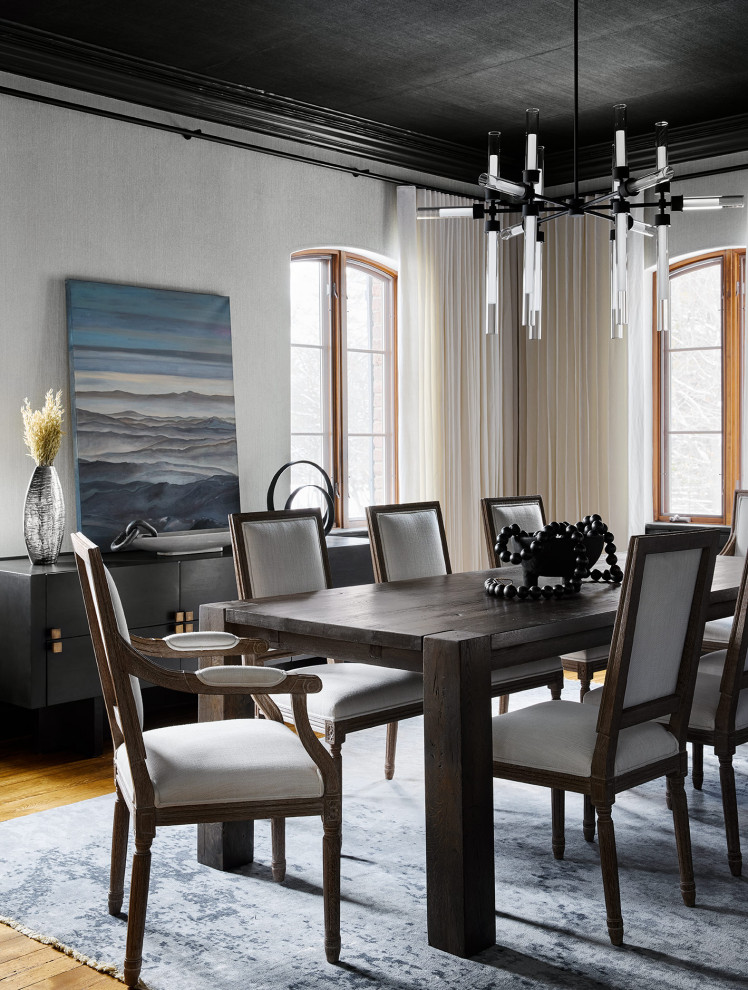 Cette image montre une grande salle à manger design fermée avec un mur gris, un sol en bois brun, une cheminée standard, un manteau de cheminée en bois, un plafond en papier peint et du papier peint.