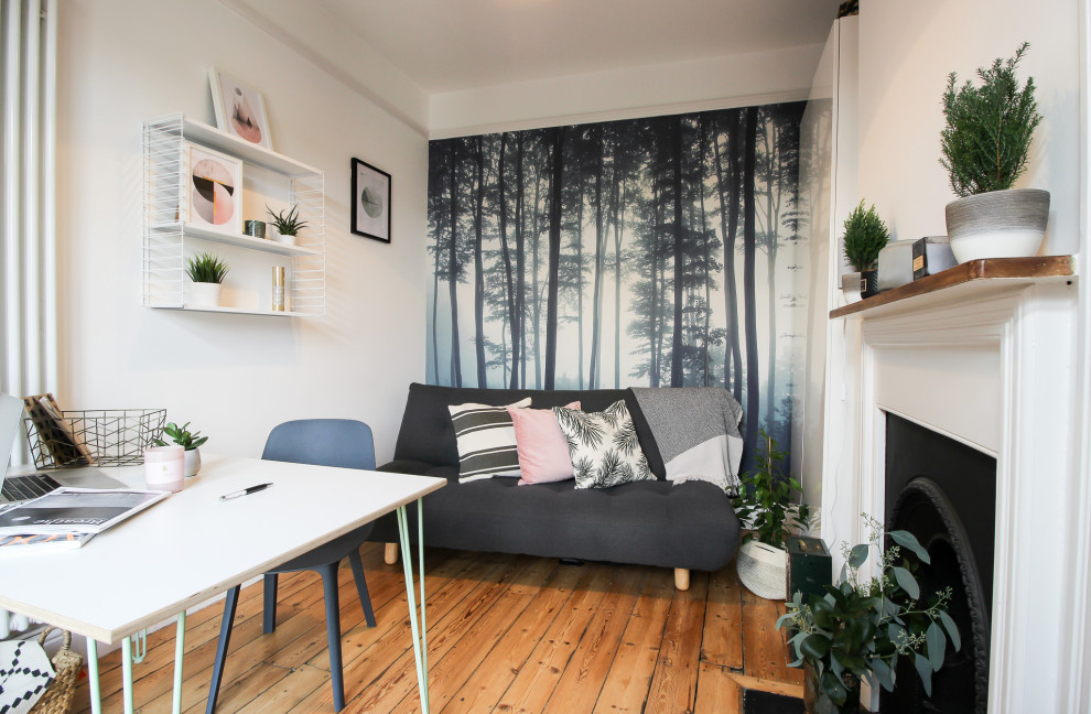 Inredning av ett skandinaviskt litet hemmastudio, med flerfärgade väggar, mellanmörkt trägolv, en standard öppen spis, en spiselkrans i metall, ett fristående skrivbord och brunt golv