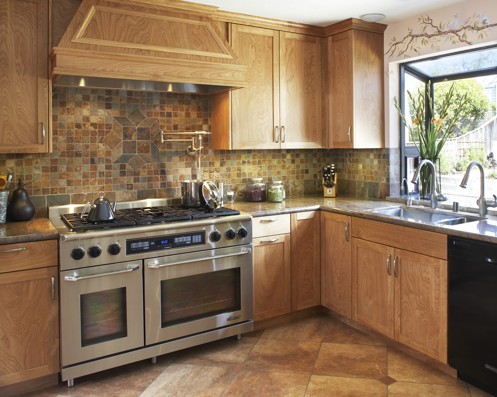 Photo of a mediterranean kitchen in San Francisco with a double-bowl sink, shaker cabinets, medium wood cabinets, brown splashback, stainless steel appliances and slate splashback.
