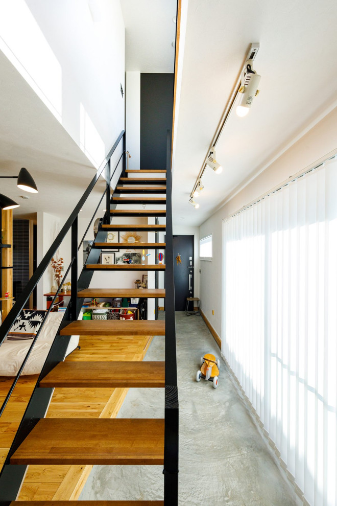 Mid-sized industrial wood straight staircase in Tokyo Suburbs with metal railing and wallpaper.