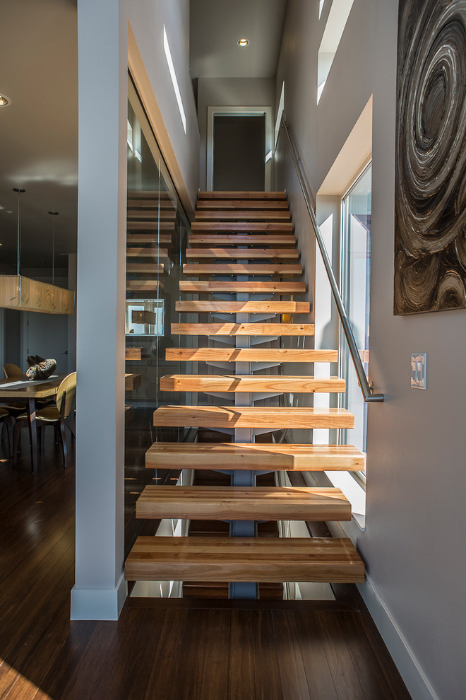 Contemporary wood staircase in Seattle with open risers and metal railing.