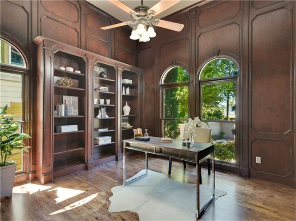 Photo of a small traditional study in Austin with brown walls, medium hardwood flooring and a freestanding desk.