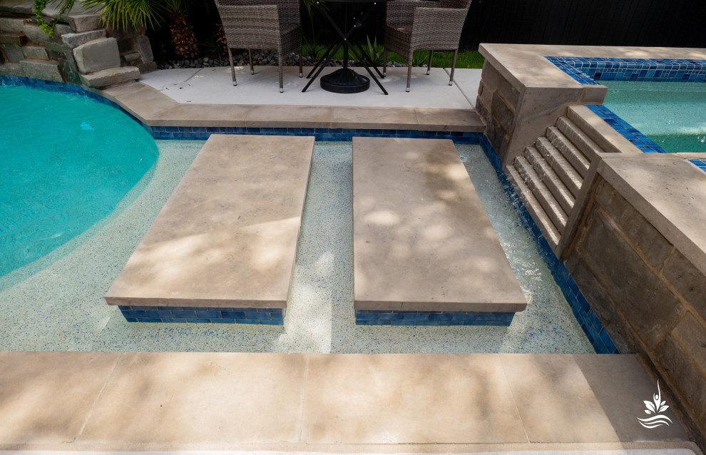 Inspiration for an expansive world-inspired back private and custom shaped natural swimming pool in Dallas with natural stone paving.