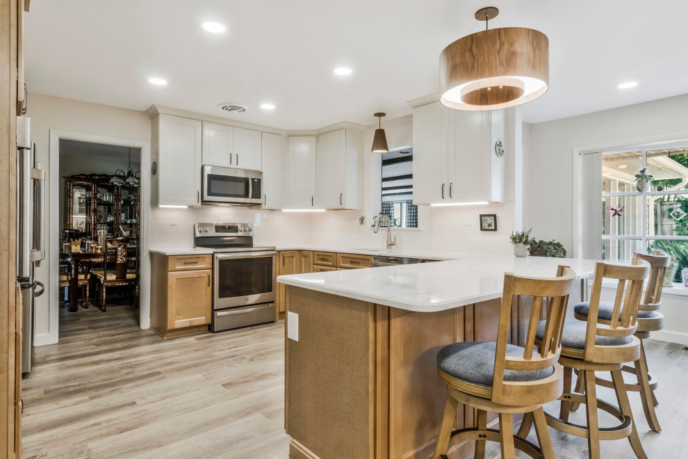 Kitchen pantry - huge transitional u-shaped kitchen pantry idea in DC Metro with an undermount sink, recessed-panel cabinets, quartz countertops, white backsplash, subway tile backsplash, stainless steel appliances, a peninsula and white countertops
