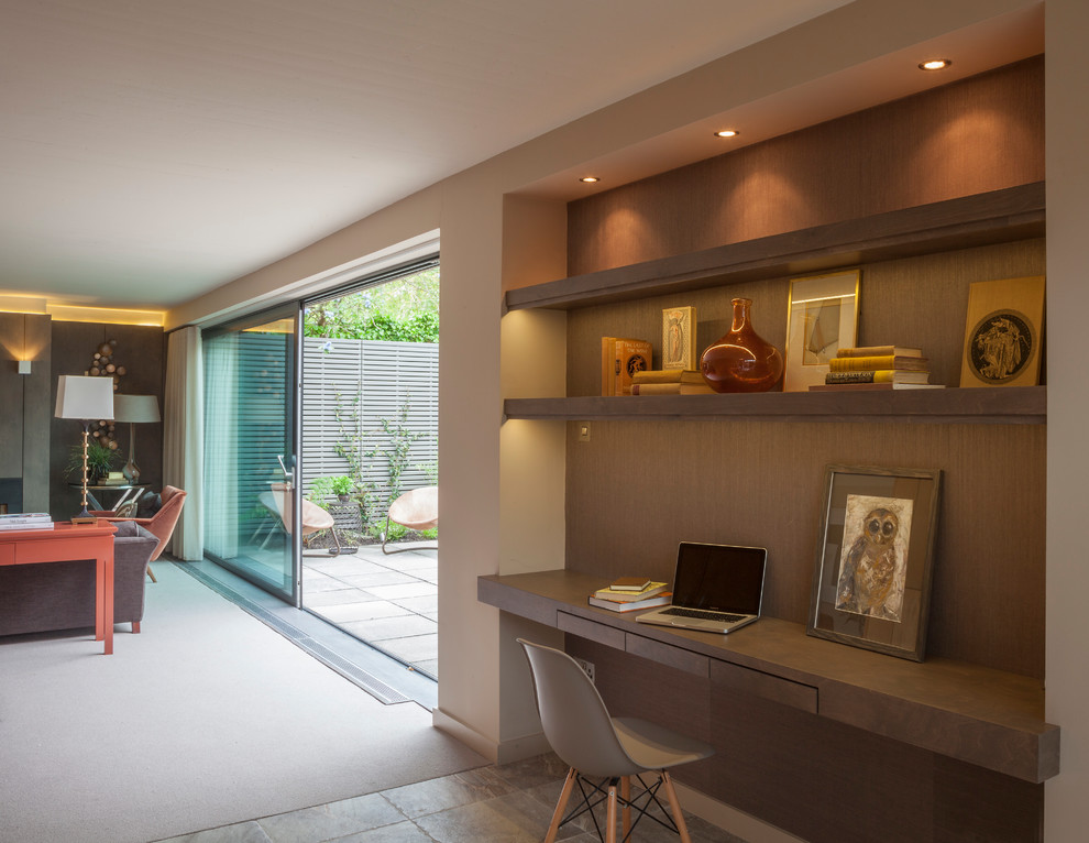 Transitional study room in Dublin with beige walls, a built-in desk and beige floor.