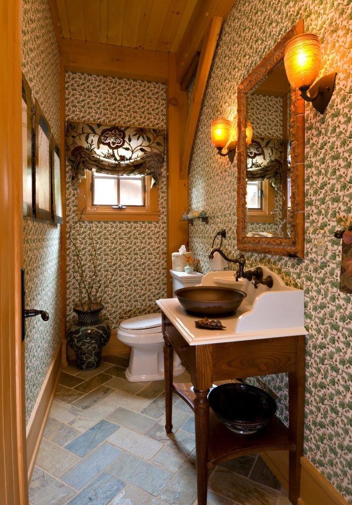 This is an example of a mid-sized country powder room in Chicago with open cabinets, dark wood cabinets, multi-coloured walls, a vessel sink, solid surface benchtops and multi-coloured floor.