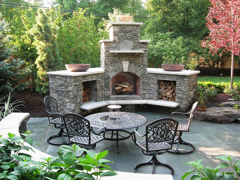 Mid-sized tropical backyard patio in Chicago with a fire feature, natural stone pavers and no cover.
