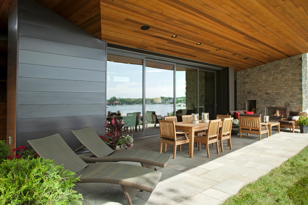 Photo of a contemporary patio in Minneapolis with a fire feature and a roof extension.