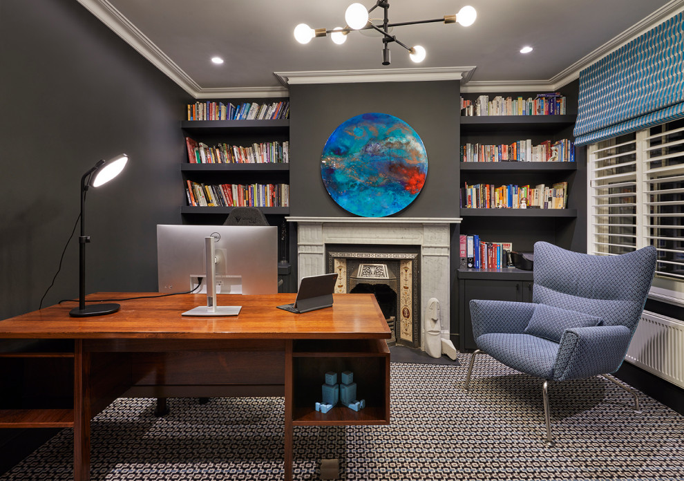 Cette photo montre un bureau tendance avec un mur noir, moquette, un manteau de cheminée en pierre, un bureau indépendant et un sol multicolore.