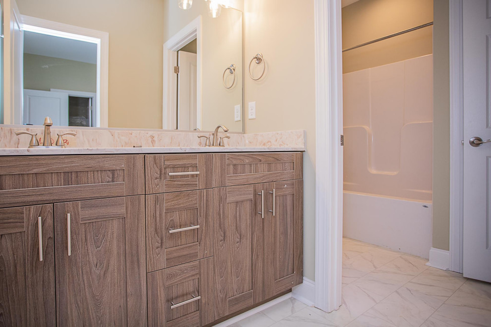 Bathroom - large craftsman kids' ceramic tile, white floor and double-sink bathroom idea in Other with recessed-panel cabinets, medium tone wood cabinets, a one-piece toilet, beige walls, an integrated sink, marble countertops, white countertops and a built-in vanity