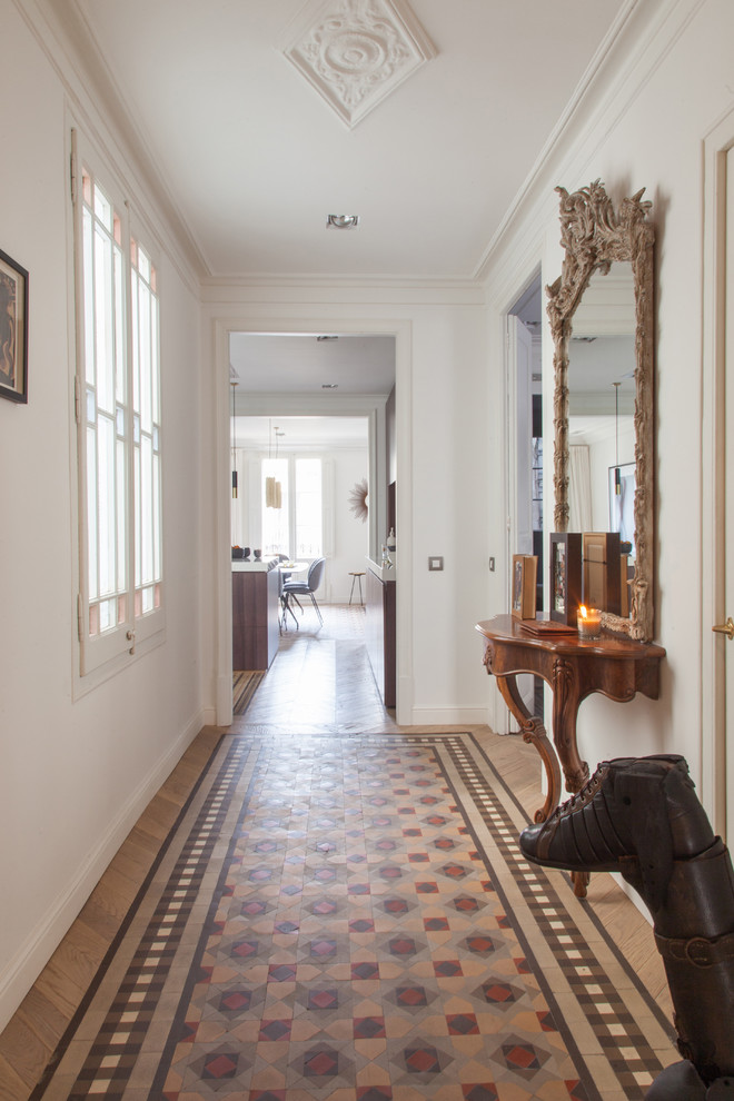 Inspiration for a mid-sized transitional hallway in Barcelona with white walls, ceramic floors and multi-coloured floor.